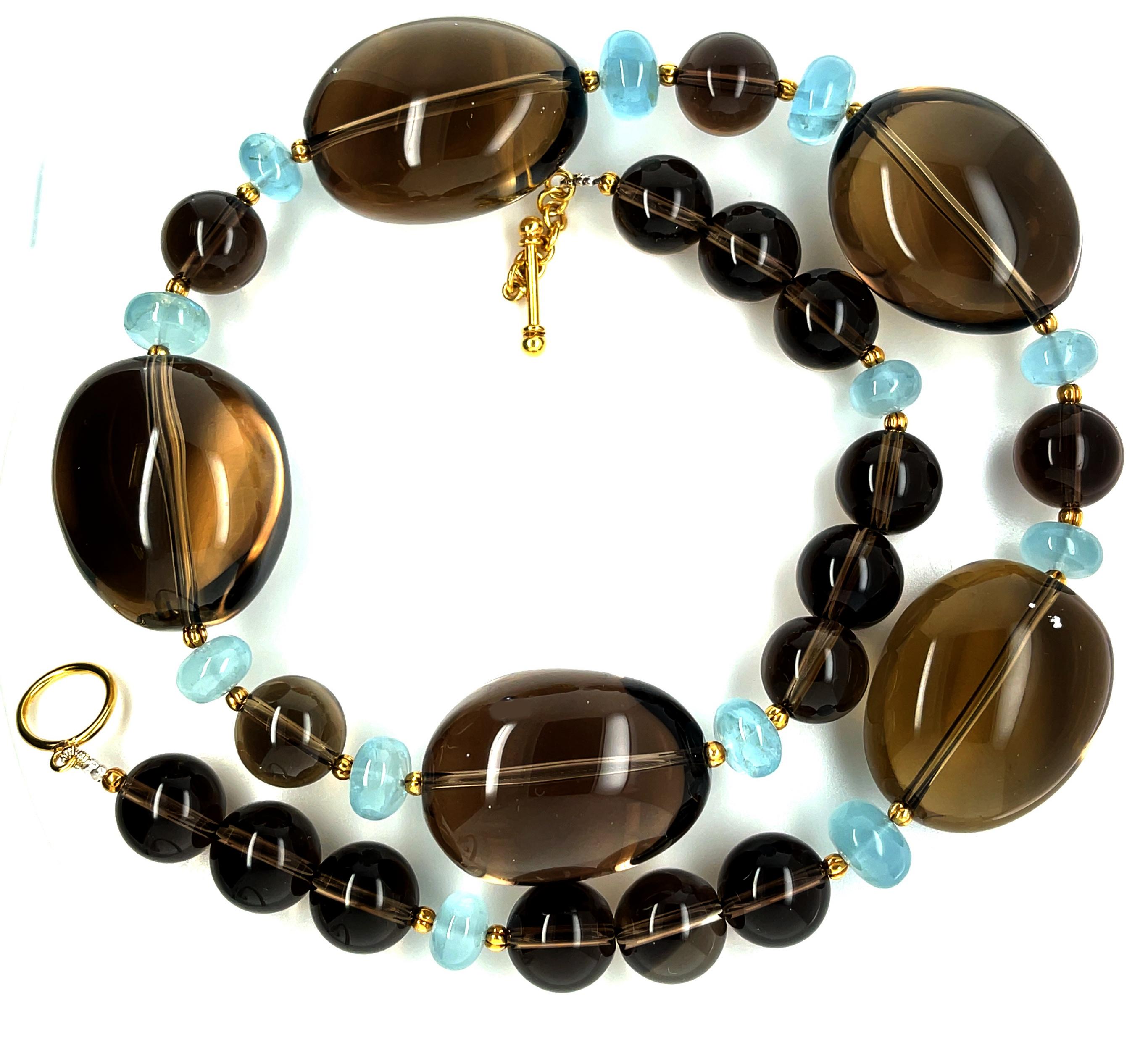 A gorgeous color pairing of warm toffee brown with cool sea glass blue is mesmerizing in this sophisticated and eye-catching necklace that combines smoky quartz with aquamarine and 18k yellow gold. Large, smoky quartz oval crystals have been