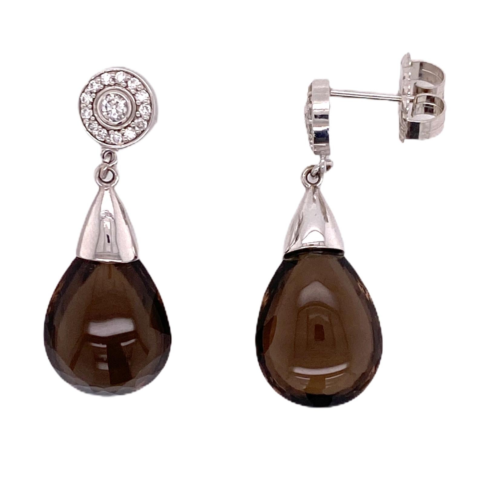 Fabulous diamond and smoky quartz drop earrings fashioned in 14 karat white gold. The earrings feature round brilliant cut diamonds weighing approximately .50 carat total weight. The drops measure 1.50 inches in length and .50 inches in width. 