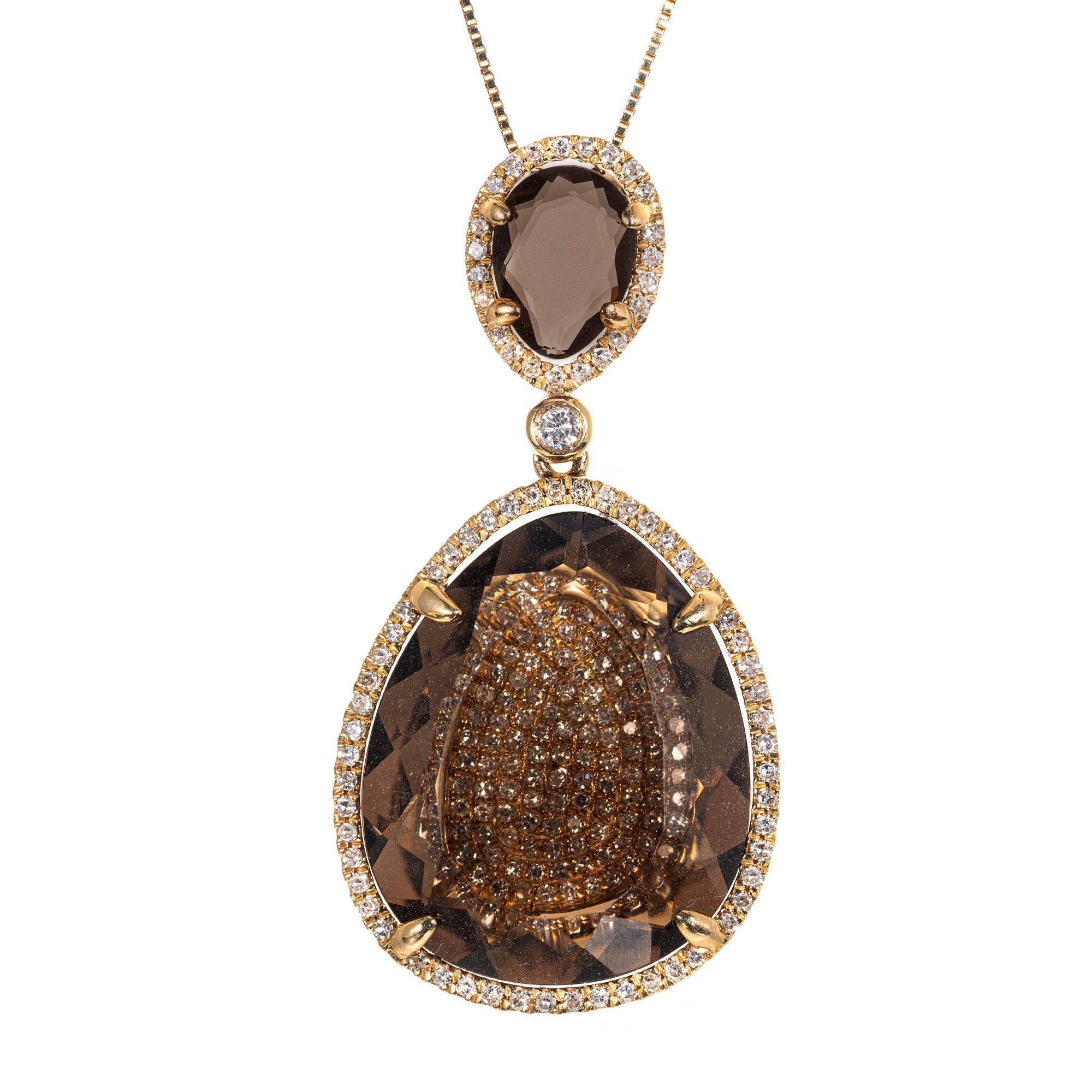 Smokey quartz and diamond pendant necklace. This unique pendant begins with a pear shaped quartz that has pave diamonds in the center that is topped off with a pear shaped  smoky quartz. The stones are connected  by around bezel set diamond. Both