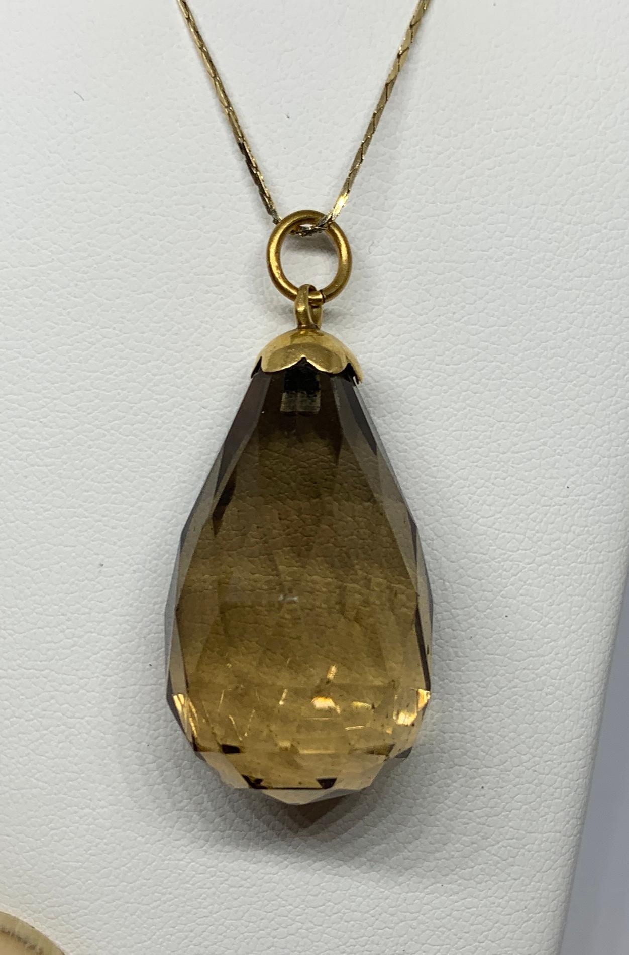 This is a classic pear shape Briolette Cut faceted Smoky Quartz Pendant Drop in 14 Karat Yellow Gold in a wonderful large size.  The beautiful smoky quartz is wonderfully faceted and is set with a scalloped shape surmount in 14 Karat gold.   The