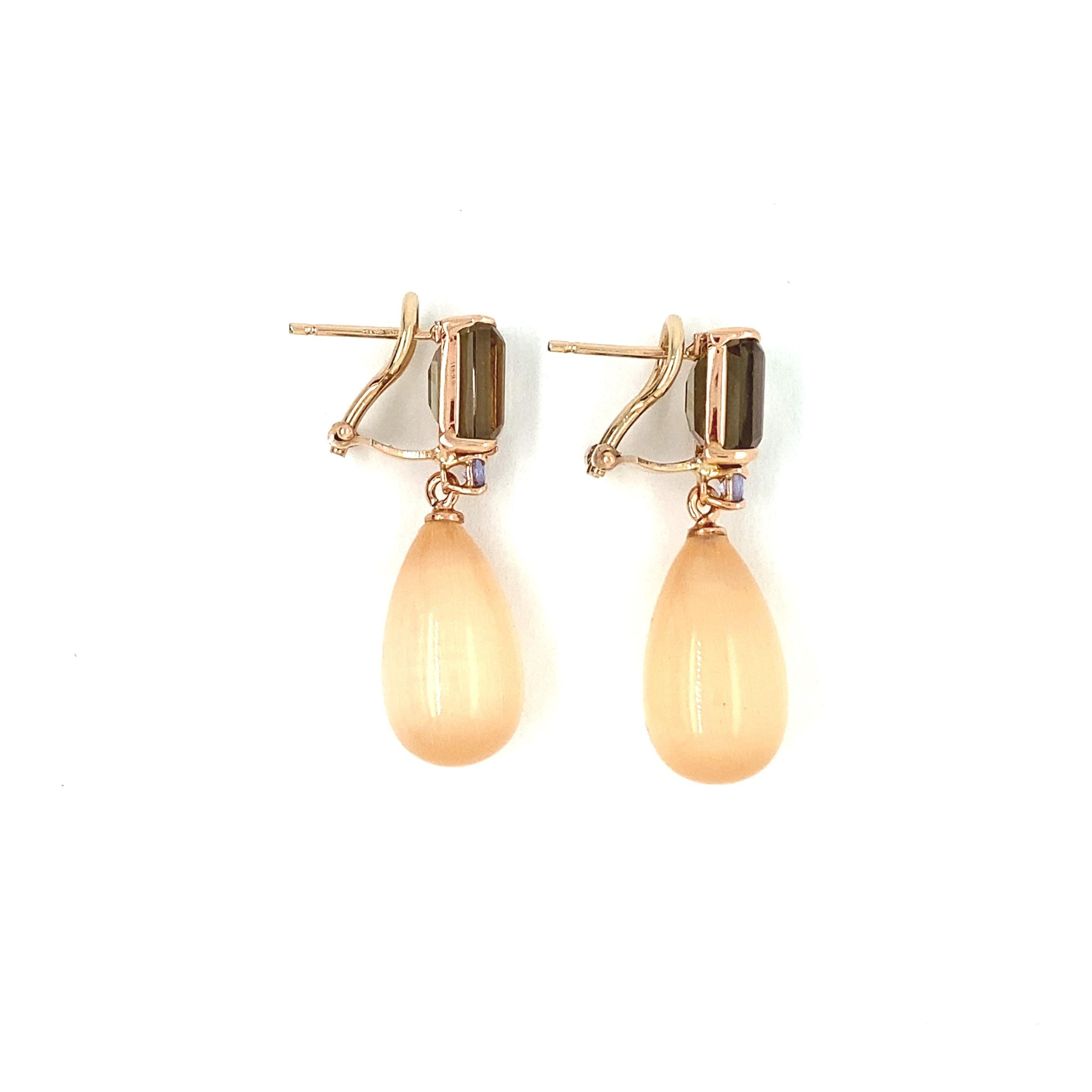 Discover these magnificent rose gold earrings, adorned with smoky quartz, tanzanite and Peach Moonstone, a creation from the French collection Mesure et Art du Temps. These earrings are a truly exceptional jewel, combining elegance, natural beauty