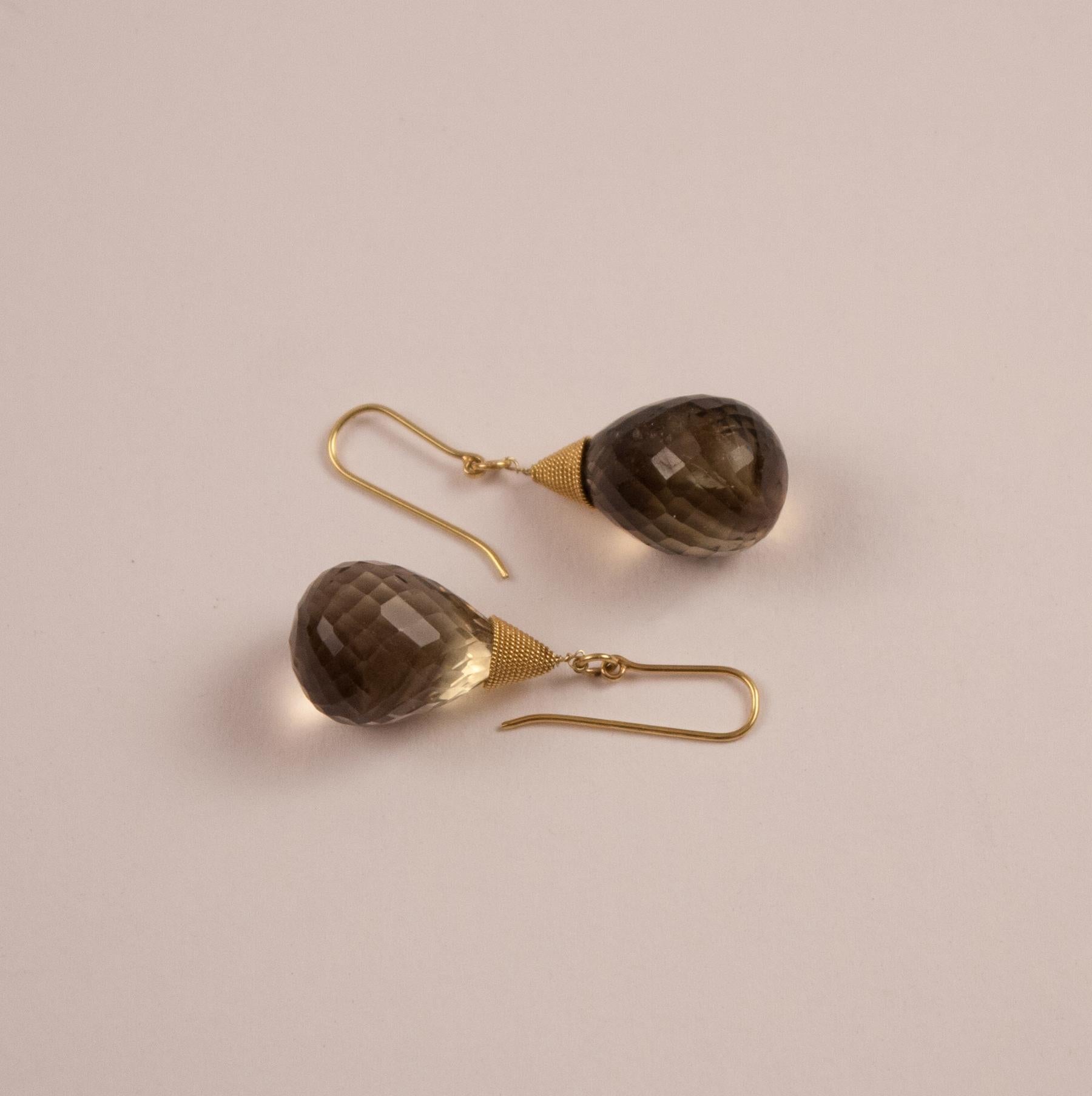 Many fine facets bring out the beautiful, shimmering tones of these smoky topaz drop earrings. In addition, the rich 18 karat gold coil fittings provide a beautiful color complement to the umber quartz.
 