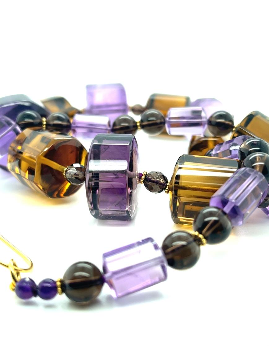 Questa collana accattivante presenta audaci perle sfaccettate a forma di barile di ametista e topazio fumé splendidamente disposte con accenti in oro giallo 18 carati. Le grandi perle trasparenti di ametista hanno uno splendido colore viola e lilla