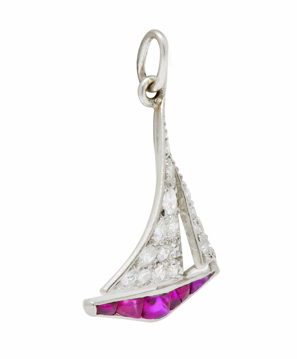 Designed as a sailboat with sails full mast and pavé set throughout by single cut diamonds weighing in total approximately 0.35 carat; eye-clean and white

Hull is channel set by calibré cut cushion ruby cabochon; transparent and a very well-matched