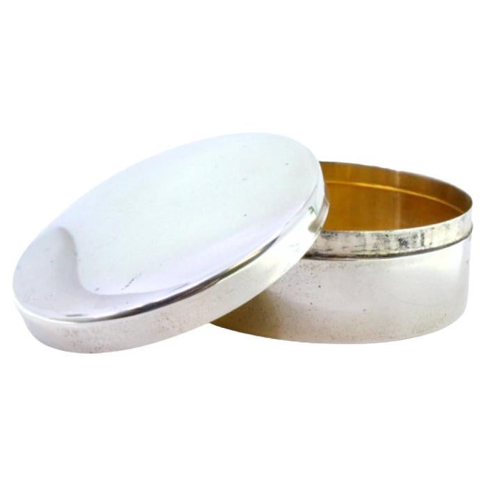 Smooth silver box in a circular shape with a gold interior