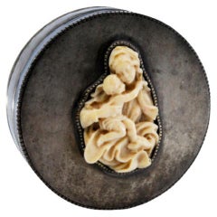 Smooth silver box w/ a circular shape & pearly edges, w/ a lady & boy on the lid