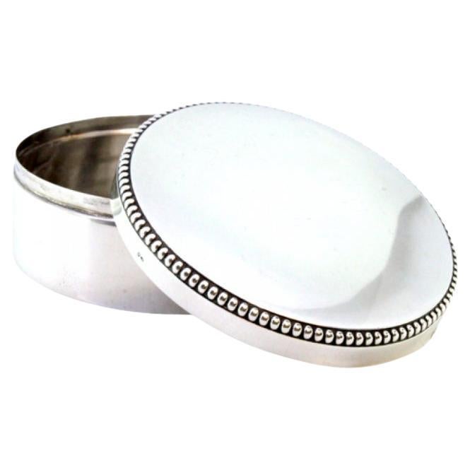 Smooth silver box with a circular shape and pearly surround