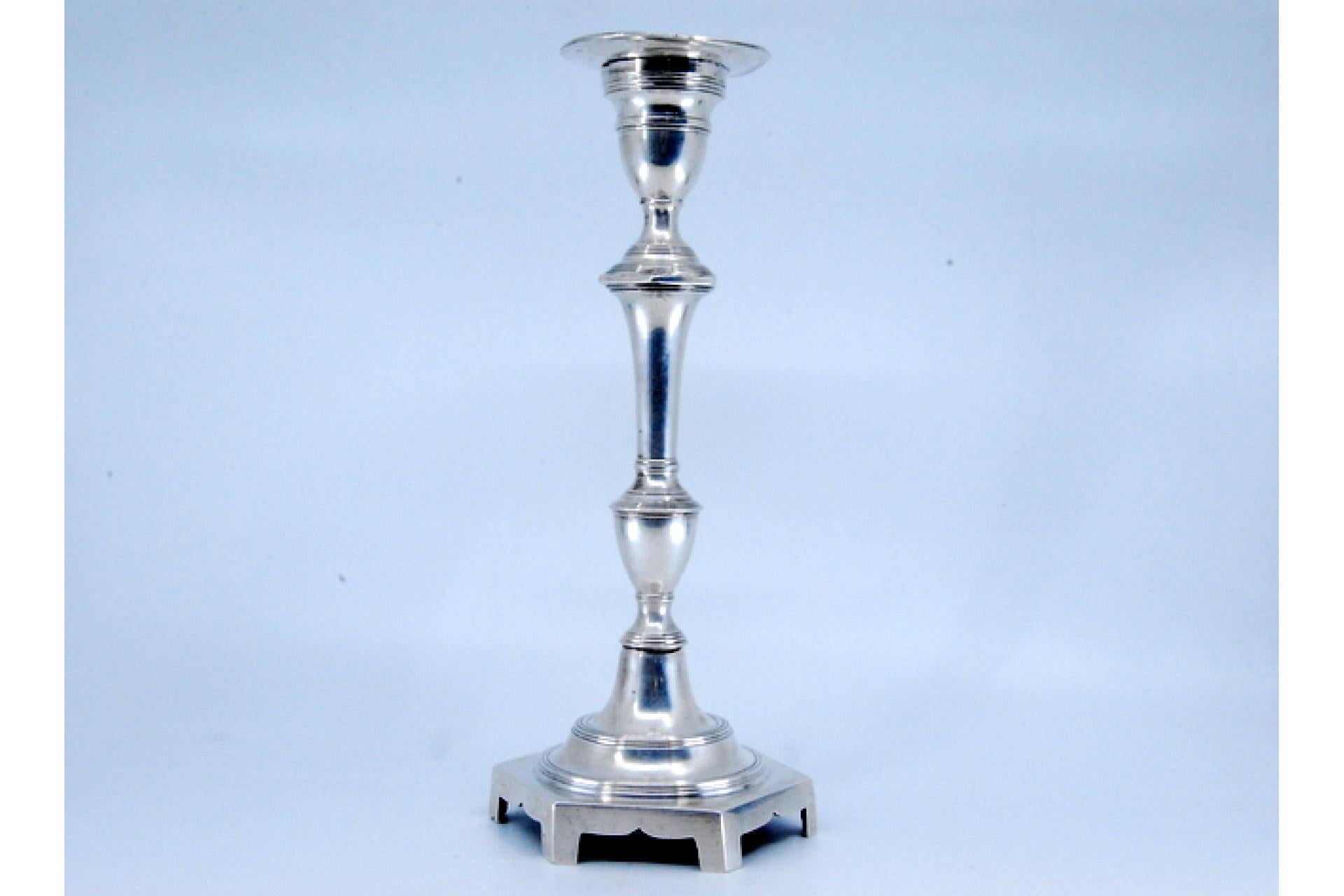 Description: Solitary candlestick in smooth silver with turned shaft and resting on a hexagonal base. Metal: Silver. Origin: Portuguese. Brand: Lisboa Corôa. Weight: 425.01 grams. Dimensions: 23x9cm. Content: 833/1000. Assay Mark: Yes, from the 19th