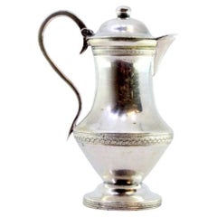 Glatte silberne Kaffeemaschine mit umlaufender Zierleiste und Knauf auf dem Klappdeckel