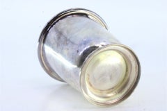 Smooth silver cup with grooves on the base and smooth handle