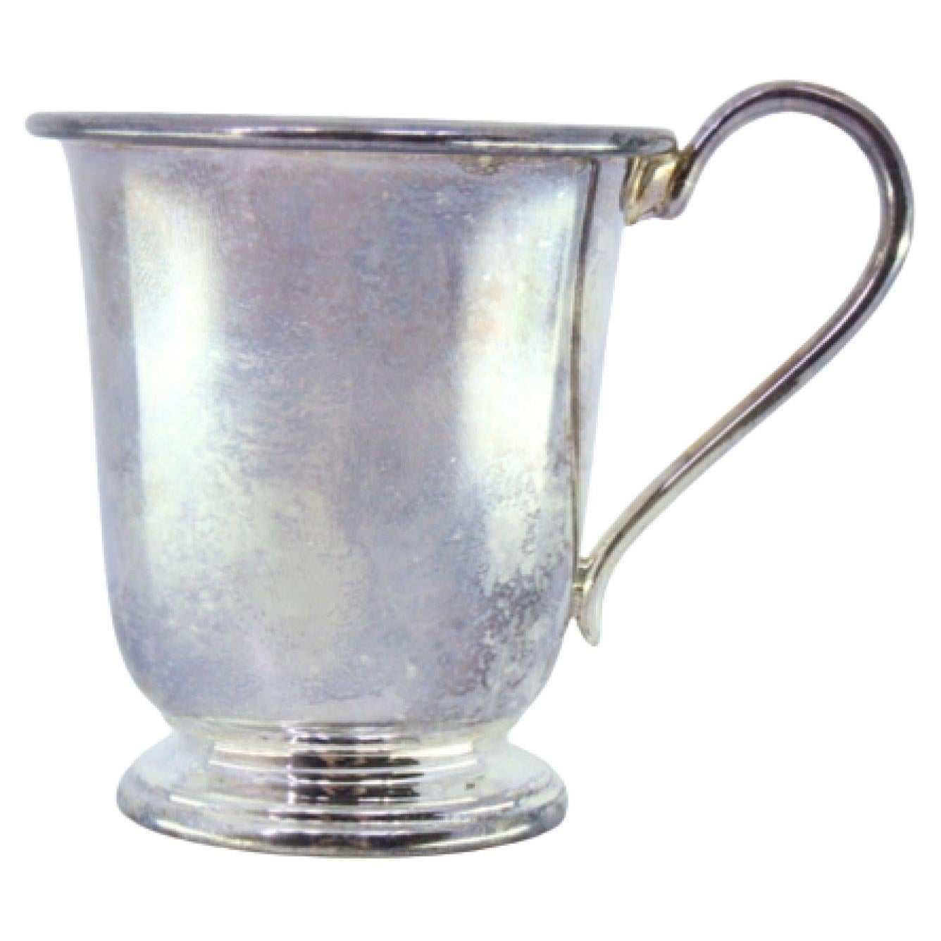 Smooth silver cup with grooves on the base and smooth handle