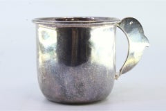 Smooth silver cup with rim trim and dolphin-shaped handle