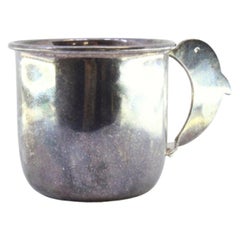 Smooth silver cup with rim trim and dolphin-shaped handle