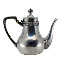 Smooth silver kettle with grooved rim and spout, raised handle and lid knob