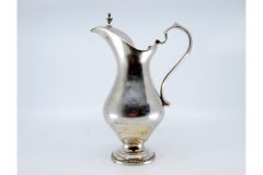 Smooth silver milk jug w/ a knob on the hinged lid & a base w/ a pearl trim