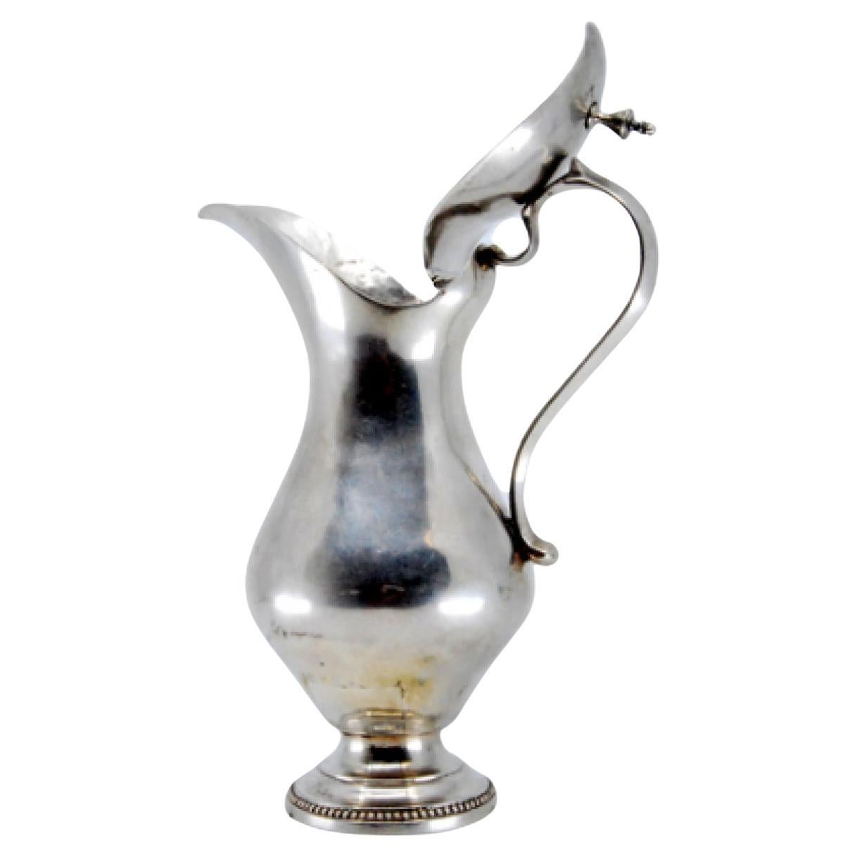 Smooth silver milk jug w/ a knob on the hinged lid & a base w/ a pearl trim