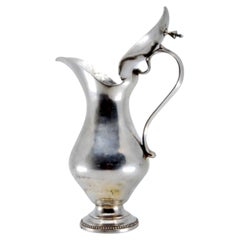 Smooth silver milk jug w/ a knob on the hinged lid & a base w/ a pearl trim