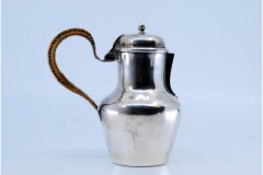 Smooth silver milk jug with straw handle and knob on the hinged lid