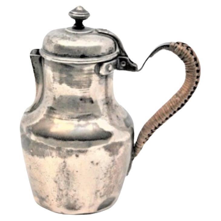 Smooth silver milk jug with straw handle and knob on the hinged lid