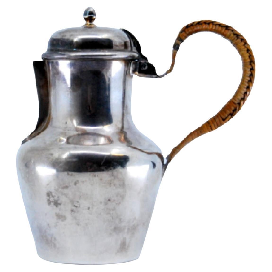 Smooth silver milk jug with straw handle and knob on the hinged lid
