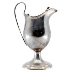 Smooth silver milk jug with strips on the base and knob on the hinged lid