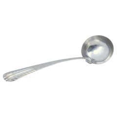 Smooth silver soup ladle with embossed handle