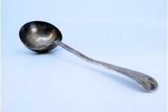 Smooth silver soup ladle with flower engraved on the handle