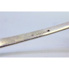 Smooth silver soup ladle with grooves along the handle