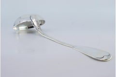 Smooth silver soup ladle with grooves along the handle