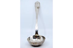Smooth silver soup ladle with grooves along the handle
