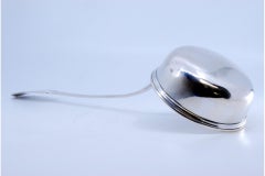 Smooth silver soup ladle with grooves along the handle