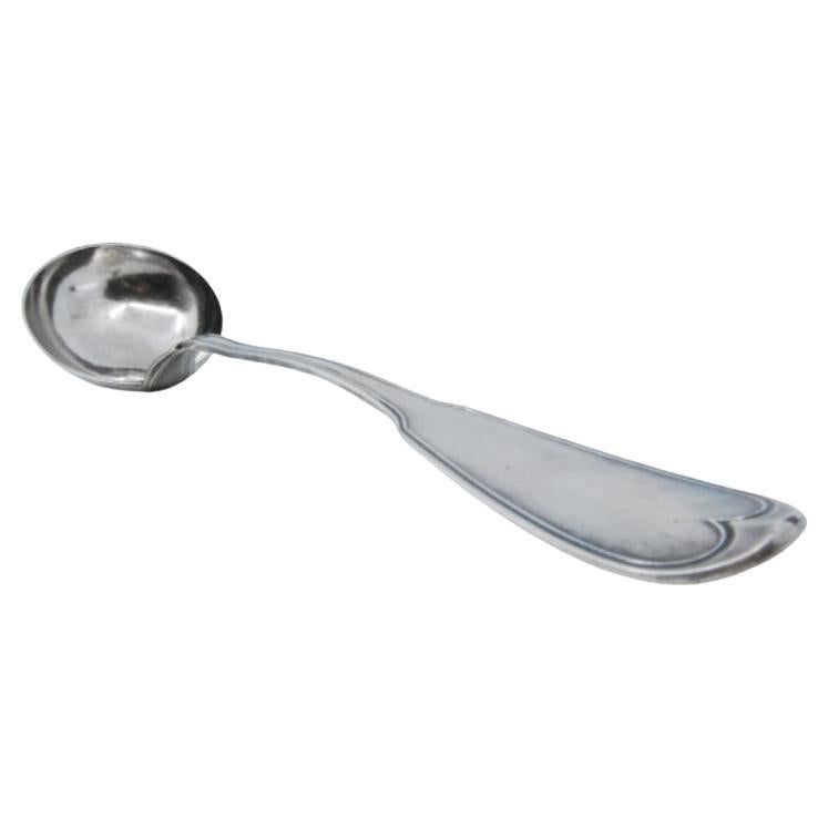 Smooth silver soup ladle with grooves along the handle