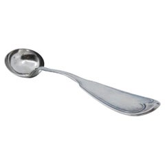 Smooth silver soup ladle with grooves along the handle
