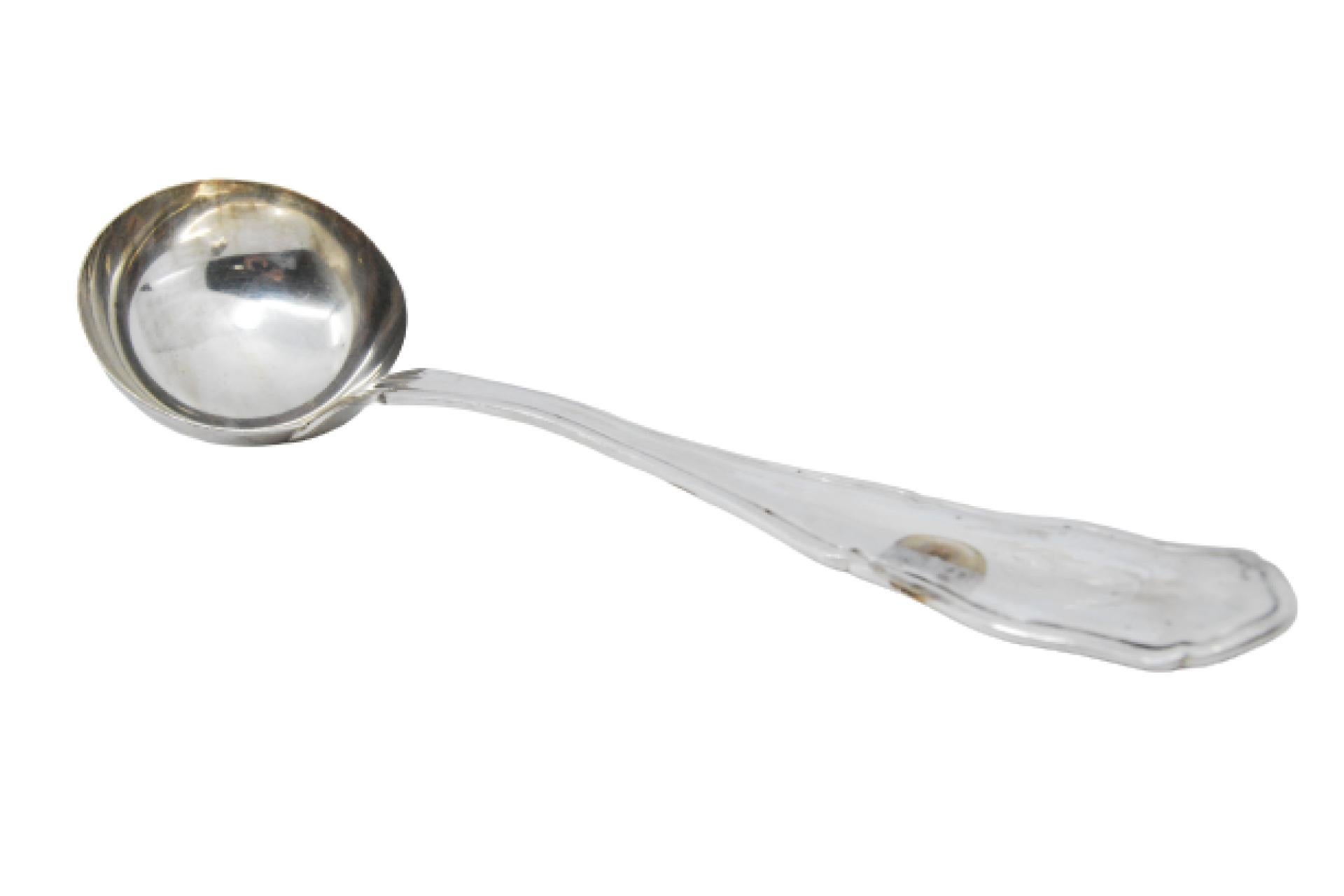 Smooth silver soup ladle with grooves along the handle