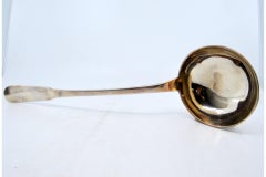 Smooth silver soup ladle with grooves on the handle