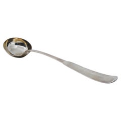 Smooth silver soup ladle with grooves on the handle