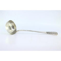 Smooth silver soup ladle with reliefs on the handle