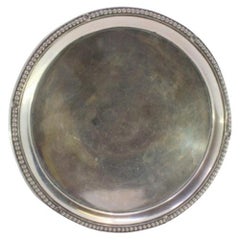Smooth silver tray with pearly rim and resting on three raised feet