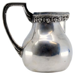 Smooth silver wine jug with reliefs on the rim