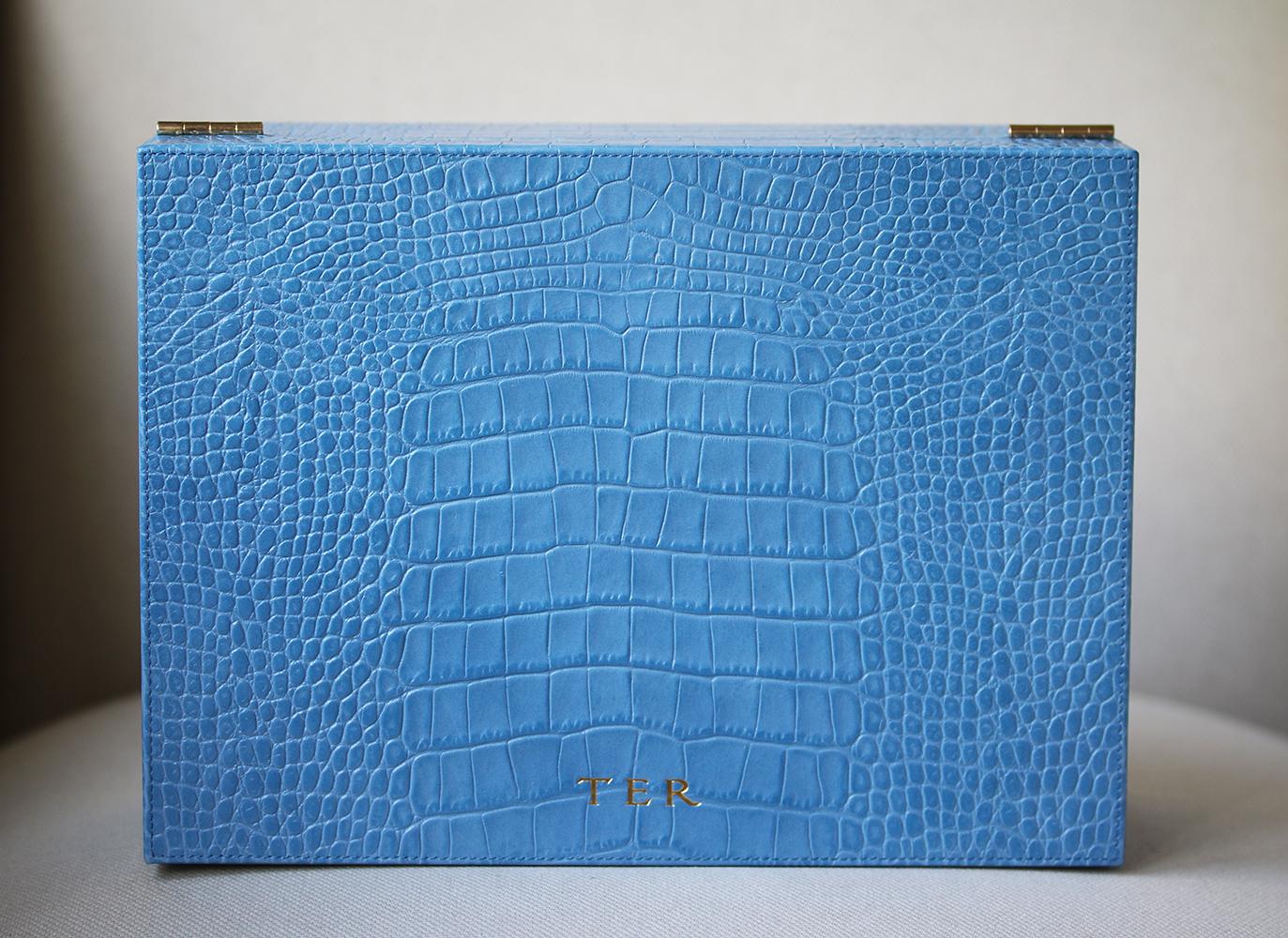 Smythson's jewelry box is part of the brand's popular glossy croc-effect leather 'Mara' collection. Updated in a light blue hue, this sturdy style is decorated with pale-gold hardware and opens to reveal a smooth nubuck lining. It contains multiple