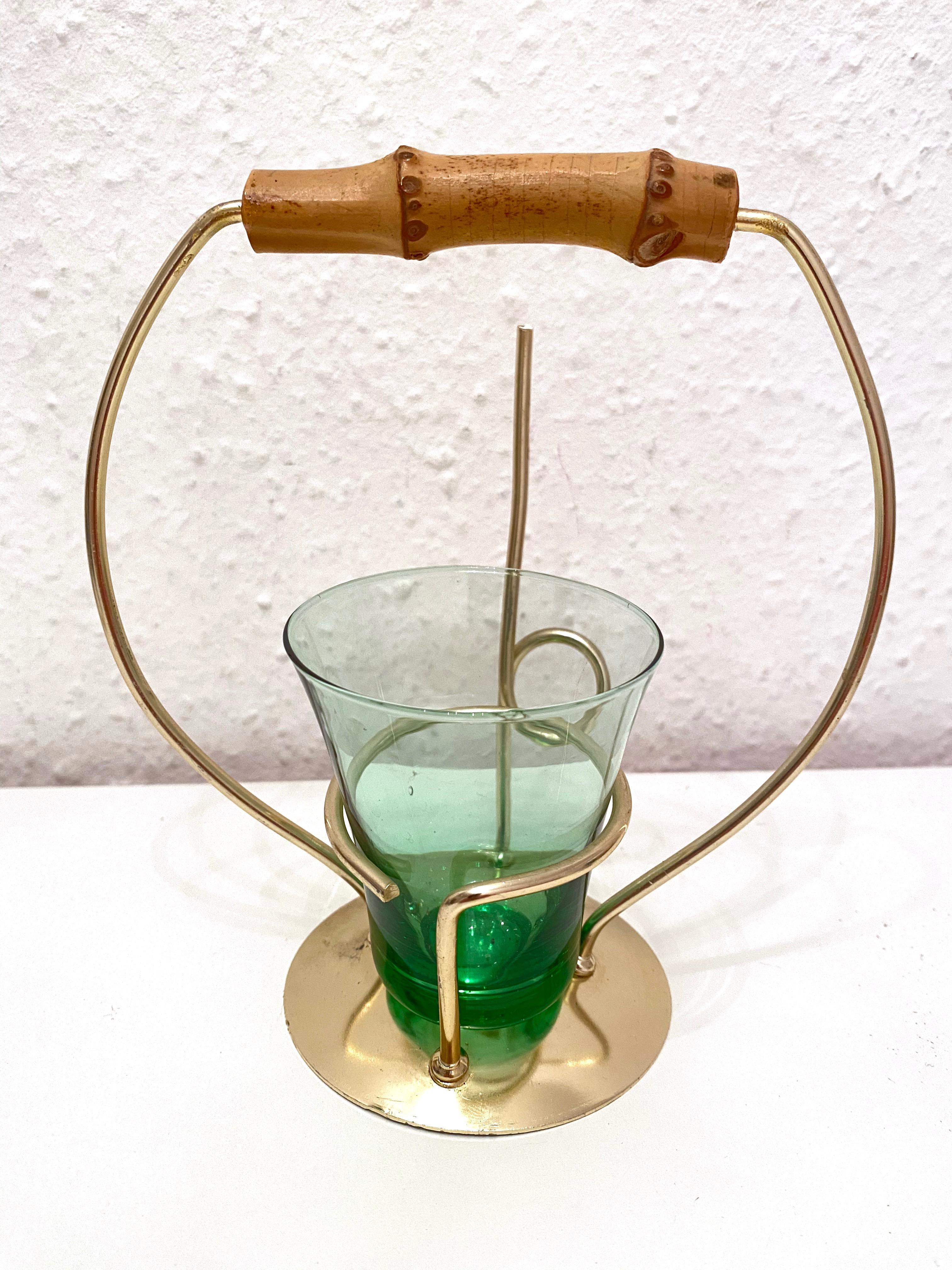 This lovely piece is typical 1950s. The glass is for salt sticks or nuts and the golden metal stand is for pretzels.
The handle is made of bamboo. The glass is green and the metal holder is in gold. The set is in very good condition.
There are no