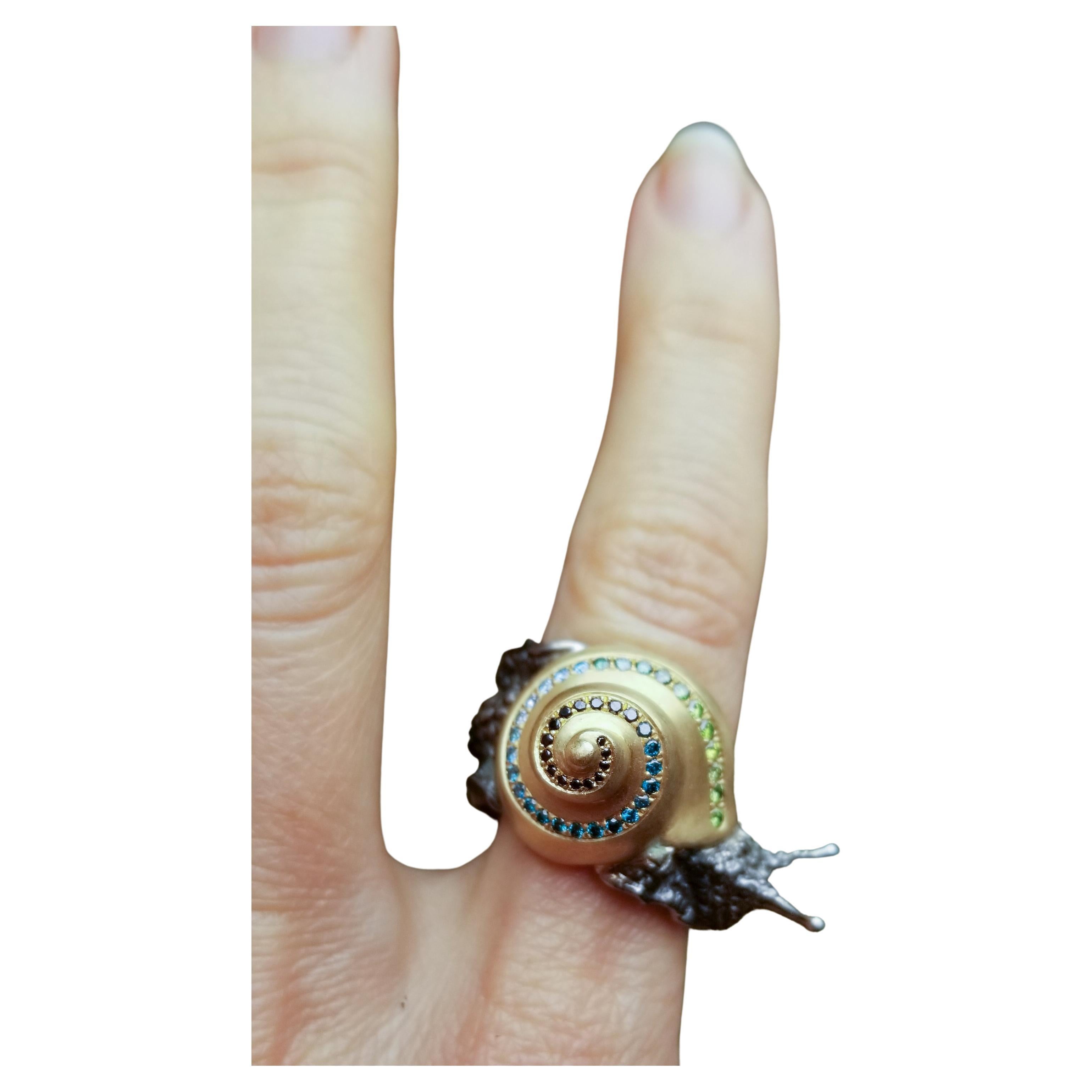 18k yellow gold, sterling silver, green and blue diamonds. One-of-a-kind.

This beautiful creature crawls comfortably around one finger.
His glossy, black-rhodium-plated silver body emerges from his satin-finished 18k recycled yellow gold shell,