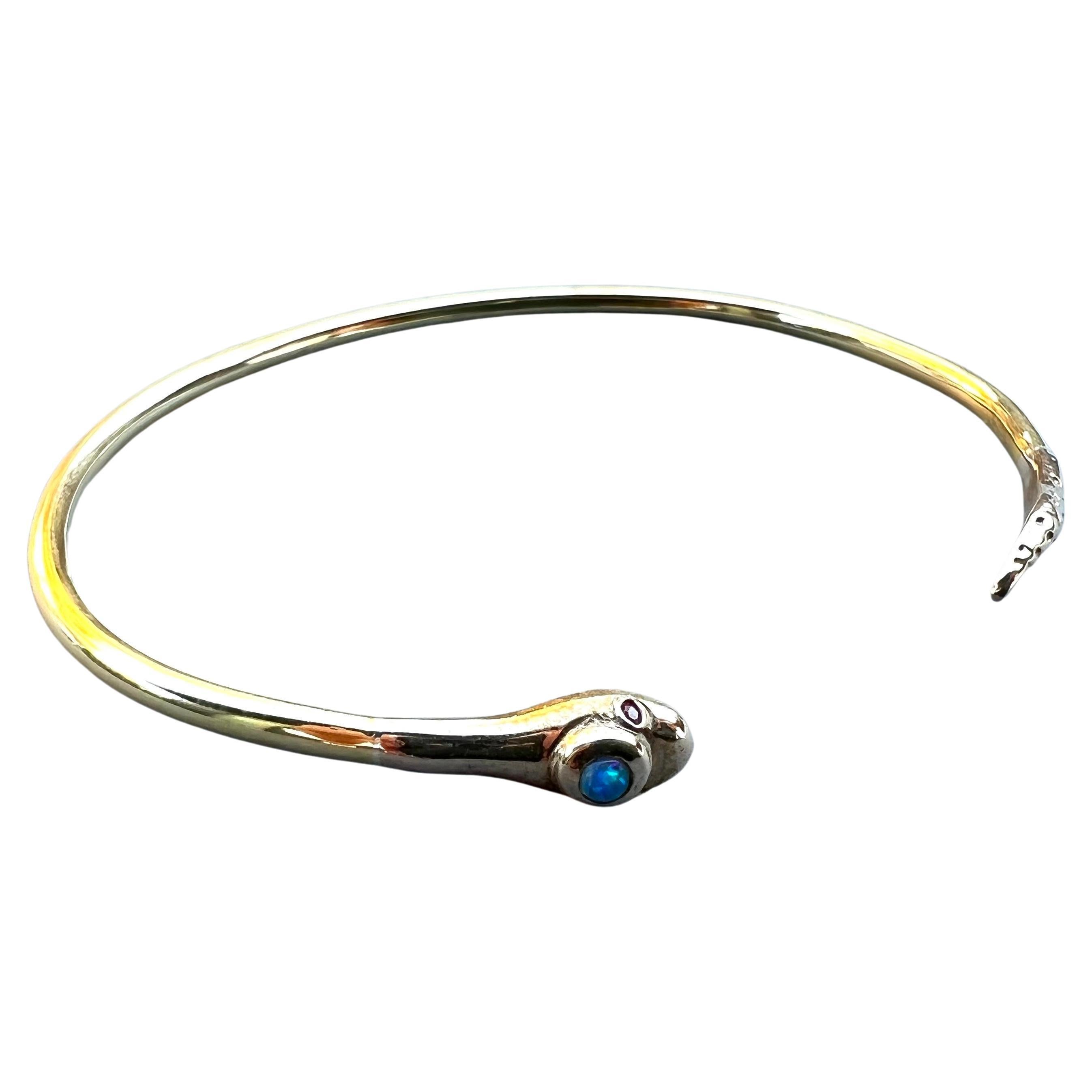 Snake Bangle with Gems Bracelet Gold Plate Opal Ruby 

By: J Dauphin

This bangle is inspired by Victorian age.
It has 2 ruby eyes and an opal on the head.

It can be customized in your size.

Hand made in Los Angeles

Made to order and will take