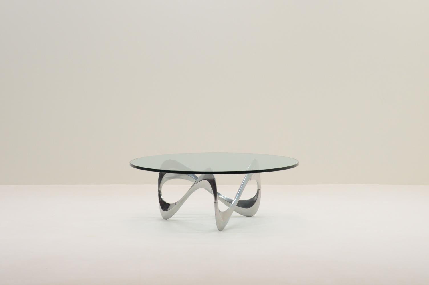 Table basse en forme de serpent par Knut Hesterberg pour Ronald Schmitt, 1960, Allemagne. La base sculpturale de la table est en aluminium poli avec un plateau en verre épais. Knut Hesterberg était connu pour son approche minimaliste et
