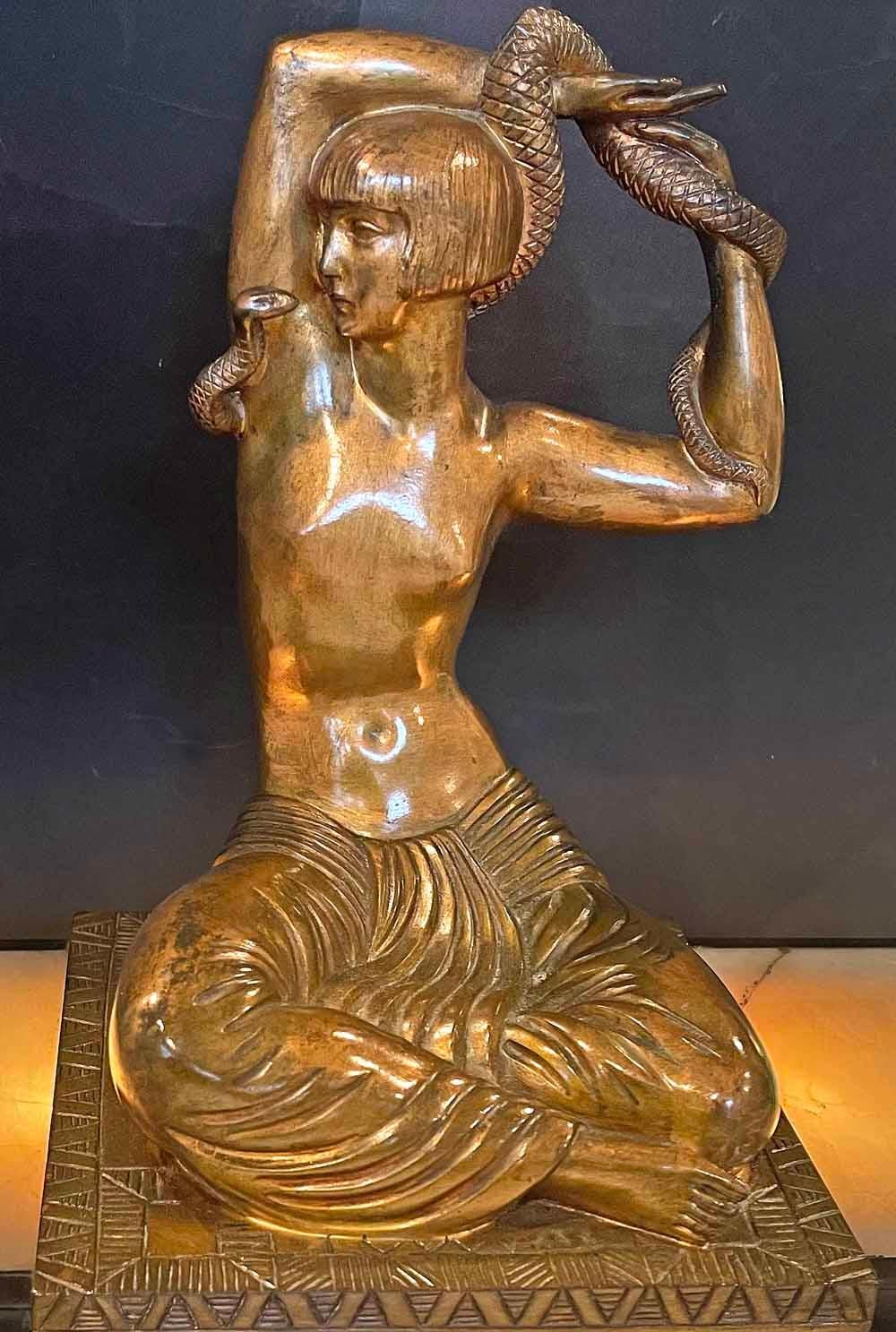 Extremely rare and very finely cast, this gilded bronze sculpture of a snake dancer in harem clothes -- but with a modern 1920s hair style -- was sculpted by Raymond Delamarre at the height of the Art Deco period in the 1920s. The nude female figure