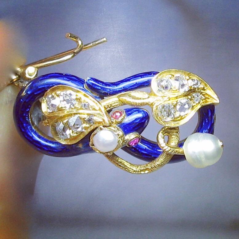 AN EXTRAORDINARY MUSEUM QUALITY PARURE OF EARRINGS AND BROOCH - THE EARRINGS IN THE FORM OF SNAKES ENTWINED WITH DIAMOND ENCRUSTED VINES, LEAVES, PEARL ADORNMENTS AND RUBY EYES.  THE BROOCH WITH DIAMONDS AND PEARLS.  ALL ADORNED WITH THE MOST