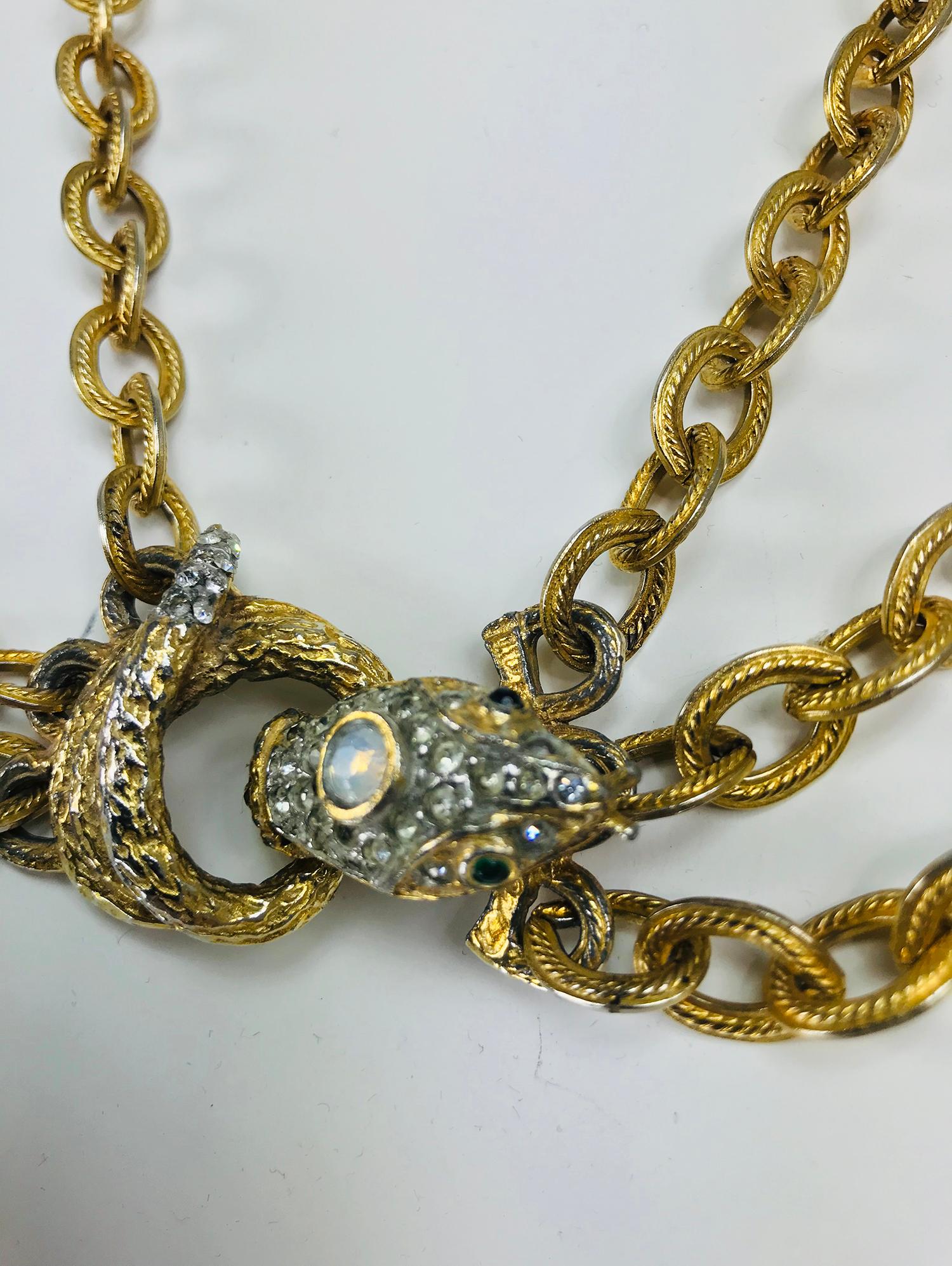 Snake festoon necklace in faux gold textured metal and crystal rhinestones, vintage. The links on the triple chains are oval and each nicely detailed. The centerpiece is the coiled snake who has a faux opal on top of it's head, faux emerald eyes and