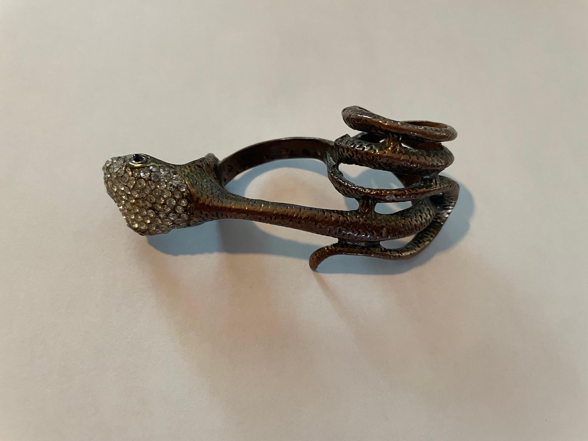 Bague serpent en laiton à porter sur 3 doigts, très originale, très bien sculptée en laiton avec des strass sur la tête du serpent et 2 petites pierres noires pour les yeux.