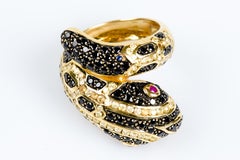 Snake ring in 18-carat yellow gold decorated with 86 black diamonds and 2 rubies