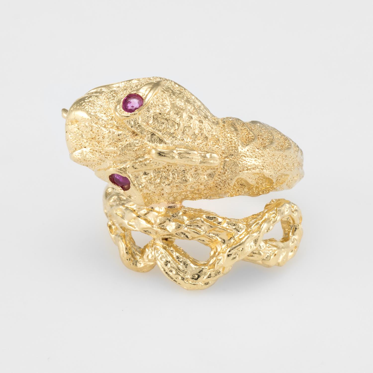 Finely detailed snake ring, crafted in 18 karat yellow gold. 

Rubies are set into the eyes and total an estimated 0.10 carats. 

For centuries the snake has represented eternal love and faithfulness. The ring is great for stacking (looks great worn